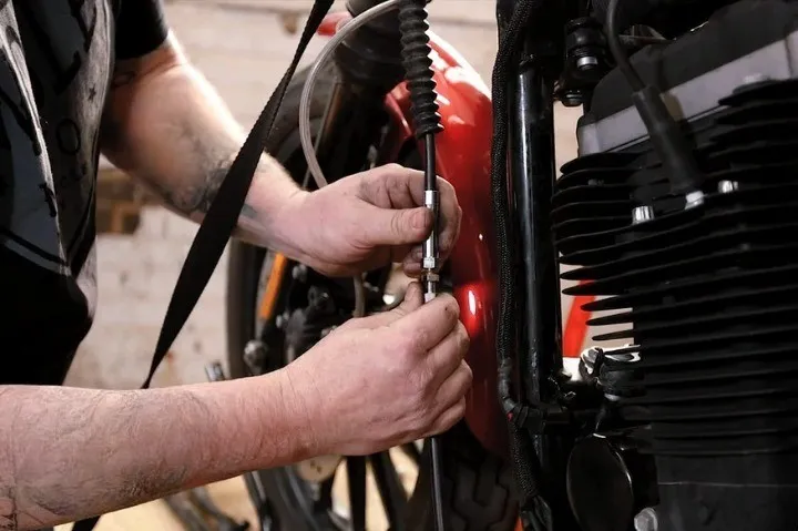 mechanic adjusting a clutch cable in a manual transmission vehicle