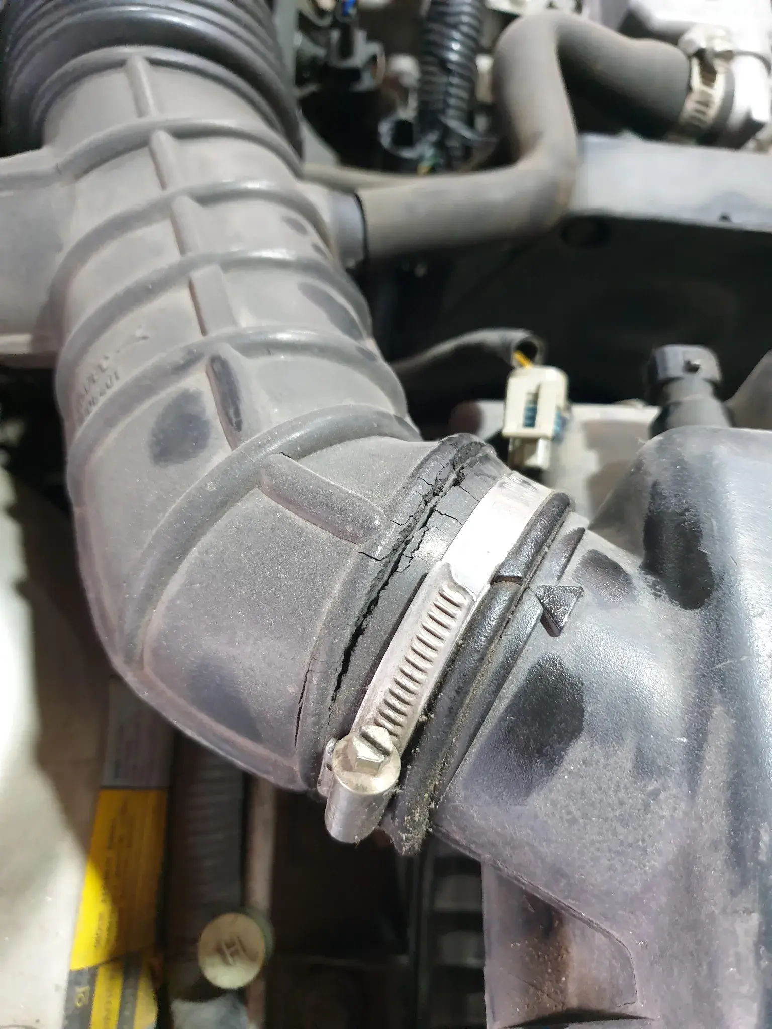 inspecting an air intake hose for cracks and wear